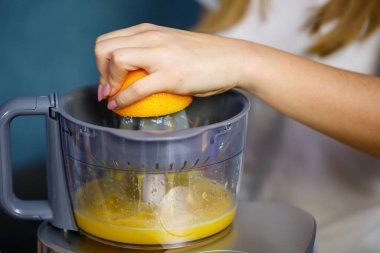 Küçük kız elma ve portakal meyvelerinden taze meyve suyu sıktı. Çocuklar için vitamin ve sağlıklı beslenme.