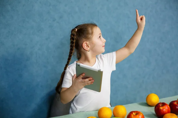 Liten Flicka Vit Shirt Håller Tablett Händerna Och Studerar Frukterna — Stockfoto