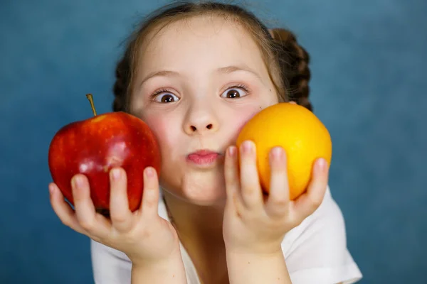 A little girl six years old loves fruits very much. Vitamins and healthy eating.