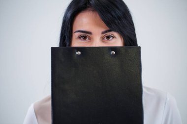 Kadın öğretmen, işletme koçu, akıl hocası elinde yeni bir iş projesi olan bir klasör tutuyor.