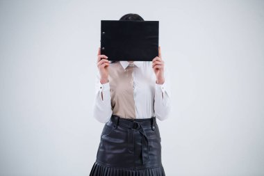 Kadın öğretmen, işletme koçu, akıl hocası elinde yeni bir iş projesi olan bir klasör tutuyor.