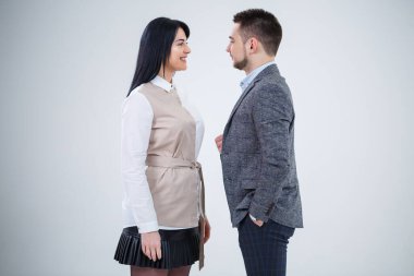 Takım elbiseli başarılı bir adam ve geleceğin iş adamları gülümsüyor ve yeni bir proje hakkında konuşuyor. İş ortakları beyaz bir arkaplanda duruyor.