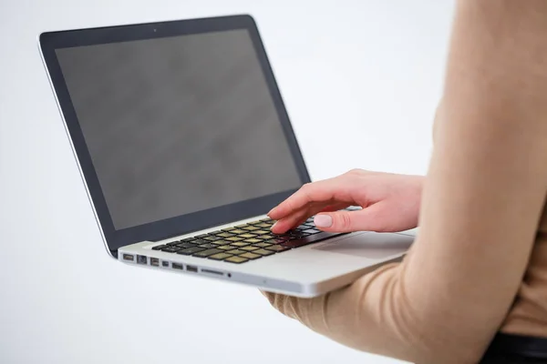 Photo of a charming woman holding a laptop and typing on business