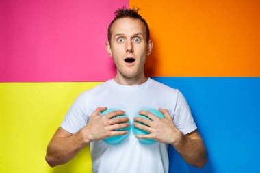 Beyaz tişörtlü genç adam, renkli arka plan, mutfak aletleri, aşçı, duygu fotoğrafları.