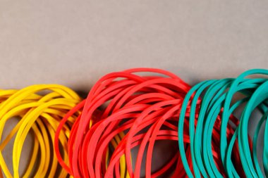Renkli bir arka planda para için renkli lastik bantlar. Kırtasiye araçları