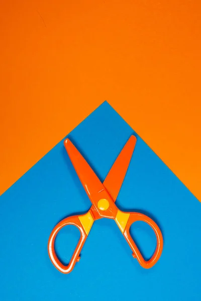 Children\'s plastic scissors for cutting paper figures on a colored background