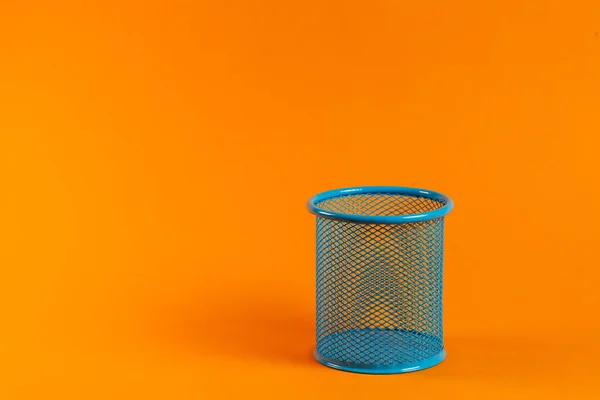 blue metal bucket for office on an orange background