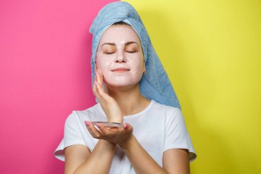 Tazelenmek ve cildini tazelemek için yüzüne ferahlatıcı bir maske takan güzel bir genç kızın portresi. Güzellik tedavileri