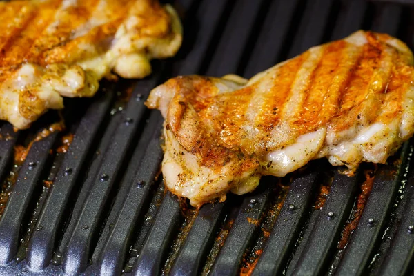 grilled chicken with spices on the electric grill in the home kitchen