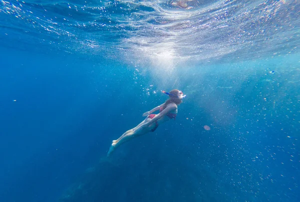 가면을쓰고 소녀는 산호와 물고기를 가지고 바다로 들어간다 — 스톡 사진