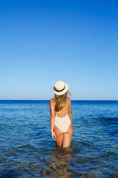 セクシーな 陽気で 明るく 公正な帽子の髪の少女は ベージュの水着で 海での休暇 — ストック写真