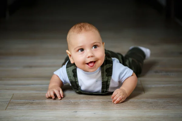 全体で8ヶ月の小さな男の子白いシャツと白い靴下が床に這って笑っています — ストック写真