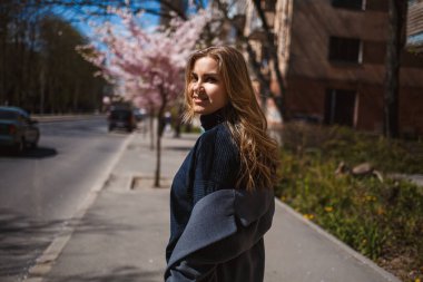 Şehrin sokaklarındaki ağaçta çiçeklerle sakura dalları. Şık bir kadın, elinde çiçekli sakurayla sokaklarda koşuyor. Açık havada çok şık bir kız. Sakura ağacı çiçek açar..