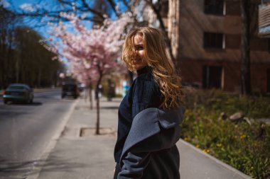 Şehrin sokaklarındaki ağaçta çiçeklerle sakura dalları. Şık bir kadın, elinde çiçekli sakurayla sokaklarda koşuyor. Açık havada çok şık bir kız. Sakura ağacı çiçek açar..