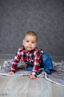 Tişört ve kot pantolon içinde 10 aylık küçük bir çocuk.