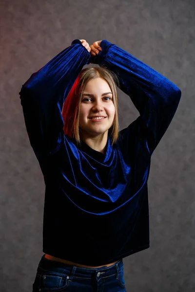 女の子で青セーターオングレー美しいですPoses背景 — ストック写真