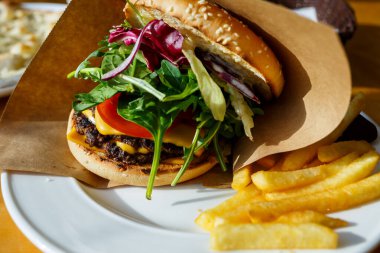 Biftek pirzolası ve kağıt bir zarfın içinde salata.