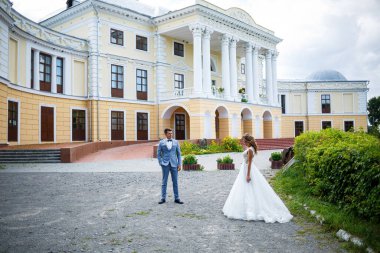 Takım elbiseli genç bir adam damat ve gelin evlendikleri gün parka trenle giden beyaz elbiseli güzel bir kız.