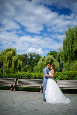 Takım elbiseli genç bir adam damat ve gelin evlendikleri gün parka trenle giden beyaz elbiseli güzel bir kız.