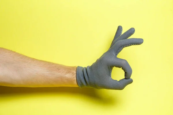 Χέρι Ανθρώπου Τεχνίτη Κηπουρού Γκρι Γάντι Κίτρινο Φόντο — Φωτογραφία Αρχείου