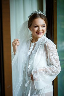 Bir düğün sabahında bornoz ve peçeyle güzel bir gelin