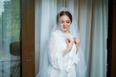 Bir düğün sabahında bornoz ve peçeyle güzel bir gelin