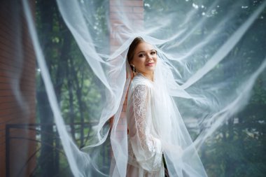 Bir düğün sabahında bornoz ve peçeyle güzel bir gelin