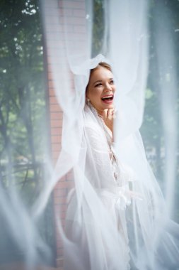 Bir düğün sabahında bornoz ve peçeyle güzel bir gelin