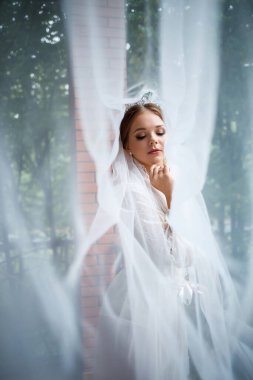 Bir düğün sabahında bornoz ve peçeyle güzel bir gelin