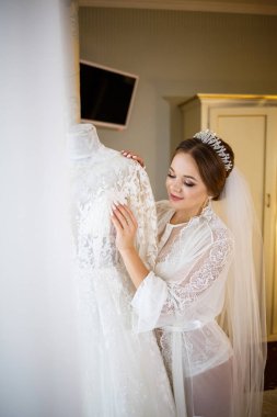 Gelin beyaz gelinliğini giyer