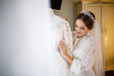 Gelin beyaz gelinliğini giyer