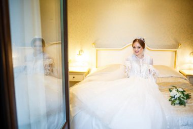 Gelin beyaz gelinliğini giyer