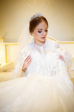 Gelin beyaz gelinliğini giyer