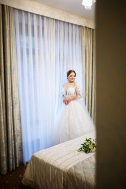 Gelin beyaz gelinliğini giyer