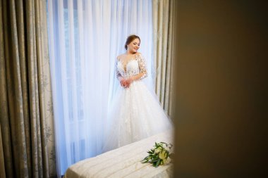 Gelin beyaz gelinliğini giyer