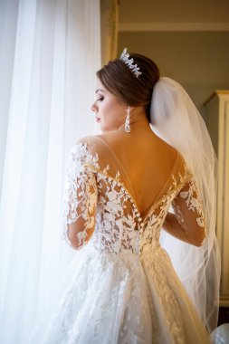 Gelin beyaz gelinliğini giyer