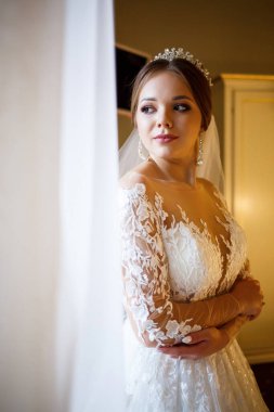 Gelin beyaz gelinliğini giyer