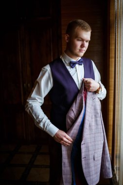 Beyaz gömlekli ve pantolonlu bir adam düğün günü giyiniyor..