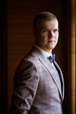 Beyaz gömlekli ve pantolonlu bir adam düğün günü giyiniyor..