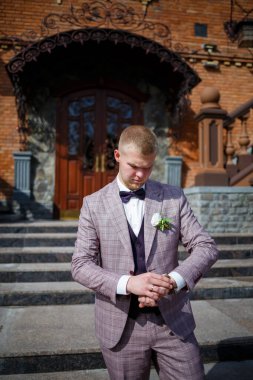 Güzel bir ekose takım elbise ve papyonlu damat.