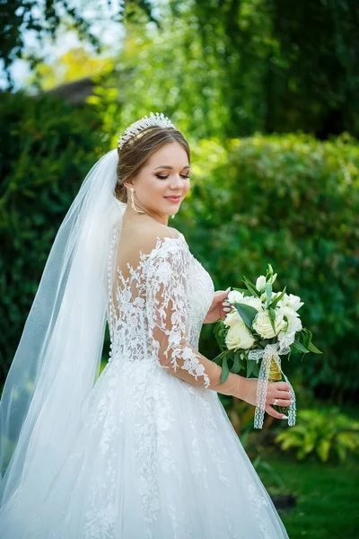 白いドレスを着た花嫁が花束を手に頭に冠をかぶせて — ストック写真
