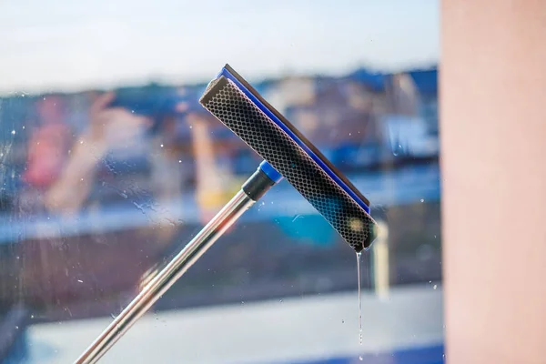 Window cleaning in high-rise buildings, houses with a brush. Window cleaning brush. Large window in a multi-storey building, cleaning service. Dust removal and glass washing.