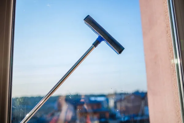 Window cleaning in high-rise buildings, houses with a brush. Window cleaning brush. Large window in a multi-storey building, cleaning service. Dust removal and glass washing.