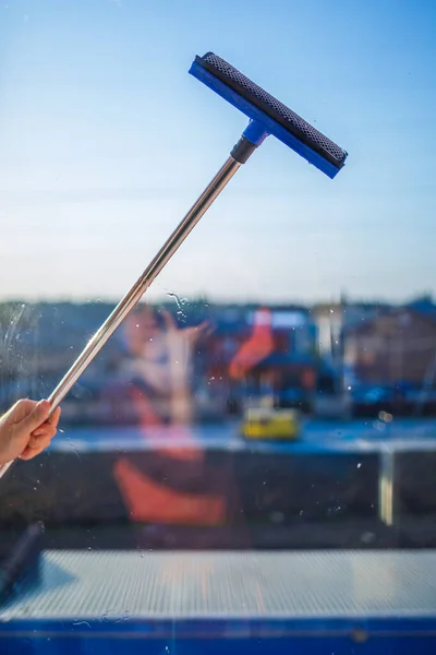 Window cleaning in high-rise buildings, houses with a brush. Window cleaning brush. Large window in a multi-storey building, cleaning service. Dust removal and glass washing.