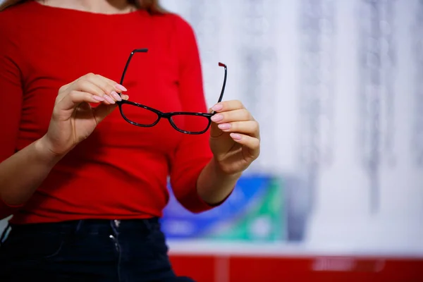 眼科中心的美女拿起眼镜进行视力矫正 — 图库照片