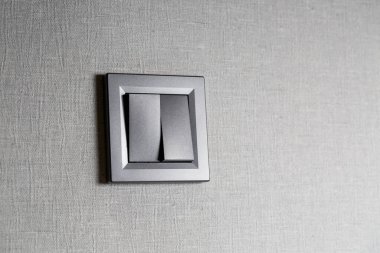 Duvarda iki anahtarlık gri bir plastik mekanik anahtar. Tadilattan sonra elektrik düğmesi takıldı. Enerji tasarrufu kavramı. Yan tarafında kopyalama alanı olan Işık Anahtarı 'nı kapat