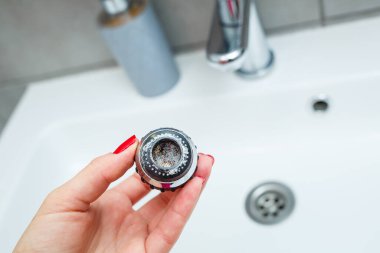 Mikserdeki su akışını ayarlamak için dönen hortum. Ellerini yıkamak için beyaz banyo lavabosu