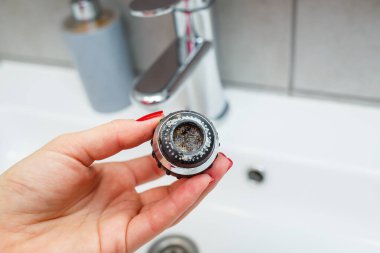 Mikserdeki su akışını ayarlamak için dönen hortum. Ellerini yıkamak için beyaz banyo lavabosu