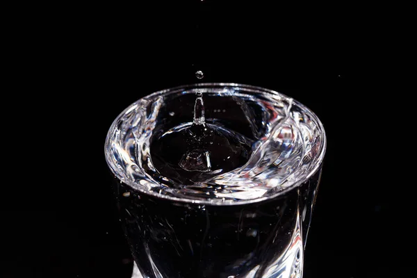 Fundo Preto Copo Que Cai Uma Gota Água Esguichando Água — Fotografia de Stock