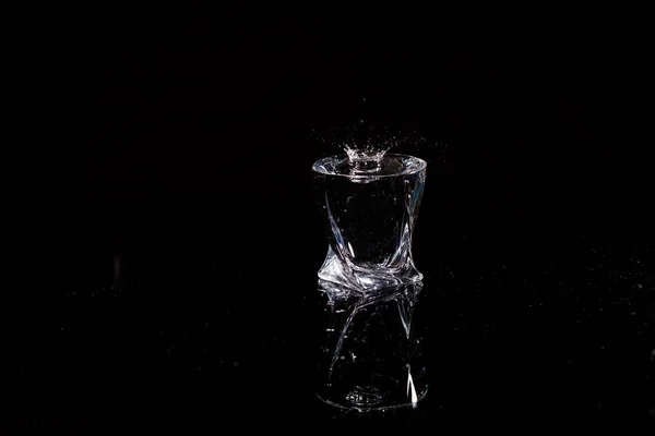 Fekete Háttér Egy Pohár Amelybe Egy Csepp Víz Esik Üvegre — Stock Fotó